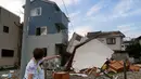 Warga Koshigaya menunjuk sebuah rumah yang rusak akibat tornado pada tanggal 2 September 2013. (AFP/Kazuhiro Nogi/wwn)