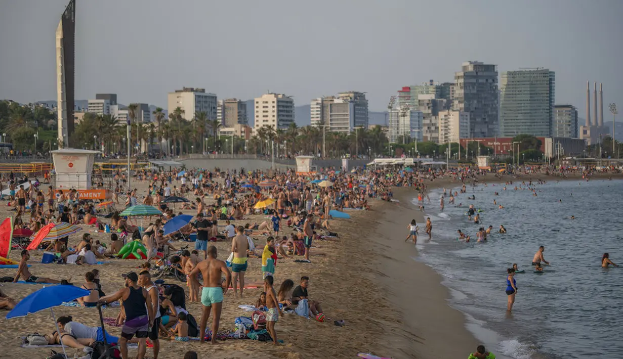 Orang-Orang menikmati cuaca panas di pantai di Barcelona, Spanyol, Kamis (12/8/2021). Bagian timur laut Spanyol, di wilayah Catalonia, diperkirakan mencapai 42 derajat Celcius pada hari Kamis. (AP Photo/Joan Mateu Parra)