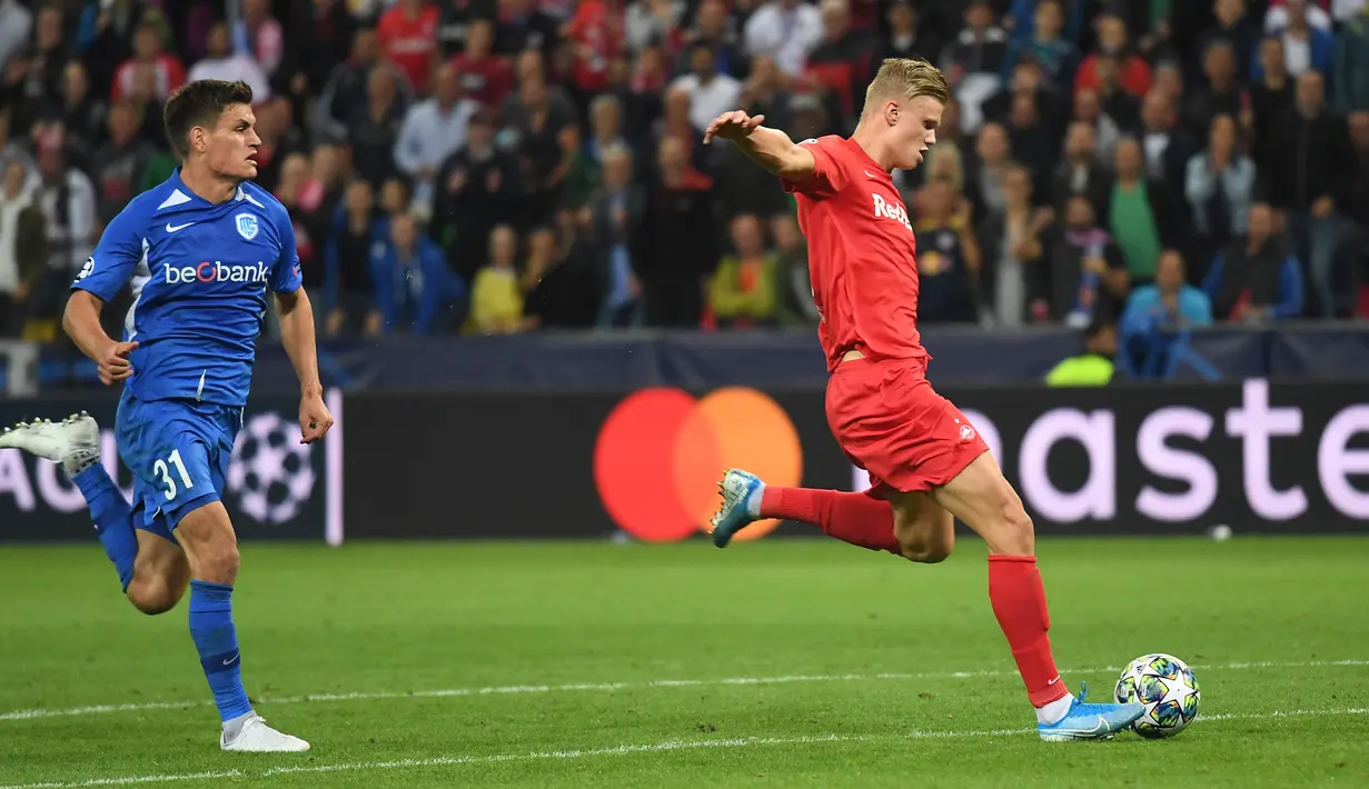 Penyerang Red Bull Salzburg, Erling Haaland menendang bola dari kejaran bek Genk, Joakim Maehle selama pertandingan grup E Liga Champions di Salzburg, Austria (17/9/2019). Haaland menjadi bintang kemenangan Salzburg saat menang telak 6-2 atas Genk. (AFP Photo/Joe Klamar)