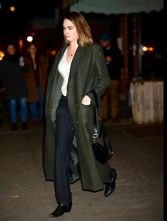 Sementara Cara menghadirkan nuansa bisnis kasual dalam balutan celana panjang bergaris-garis hitam, sweater v-neck putih dengan kancing di tengah, dan mantel panjang bagus lainnya, miliknya dalam balutan dalam warna hijau. Ia melengkapi penampilannya dengan alas kaki lucu berupa sepatu bot koboi hitam dan dompet hitam. [Foto: IG/@thehapablonde]