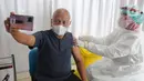 Seorang pria lansia berswafoto saat disuntik vaksin COVID-19 dosis ketiga di RSUD Tangerang Selatan, Rabu (12/1/2022). Lebih dari 60 warga lanjut usia (lansia) Tangsel mendapatkan vaksinasi lanjutan (booster) COVID-19 dengan jenis Pfizer. (merdeka.com/Arie Basuki)