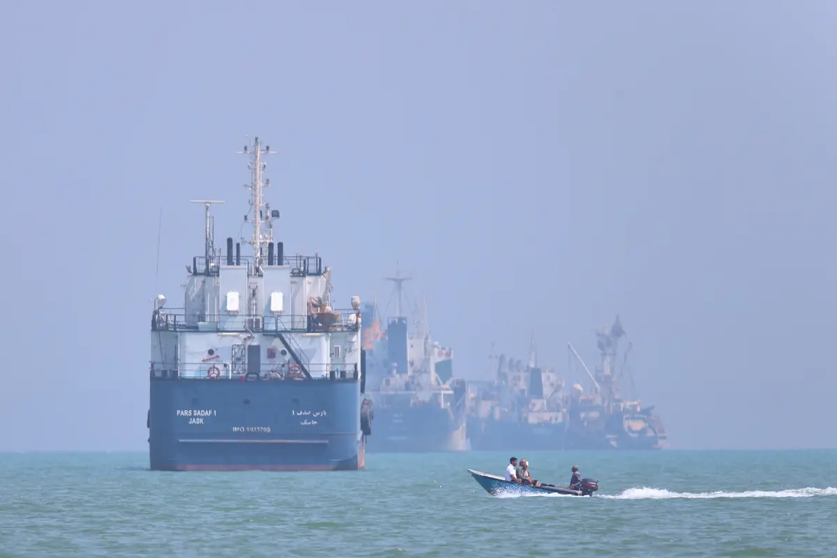 Sebuah perahu motor kecil melewati kapal-kapal yang berlabuh di Selat Hormuz di lepas pantai Bandar Abbas, Iran, Kamis, 11 Juni 2026. (Amirhosein Khorgooi/ISNA via AP)
