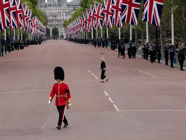 Seorang prajurit King's Guard melintasi The Mall di luar Istana Buckingham sebelum prosesi pemakaman Ratu Elizabeth II di pusat Kota London, Inggris, Senin (19/9/2022). Ratu Elizabeth II yang meninggal dalam usia 96 pada 8 September 2022, akan dimakamkan di Windsor bersama mendiang suaminya, Pangeran Philip, yang meninggal tahun lalu. (AP Photo/Christophe Ena, Pool)