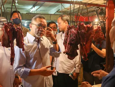 Menteri Perdagangan Zulkifli Hasan berbincang dengan pedagang daging saat meninjau harga bahan pokok di Pasar Cibubur, Jakarta, Kamis (16/6/2022). Kunjungan tersebut dilakukan untuk melihat dan memantau langsung harga bahan pokok guna memastikan harga stabil menjelang Hari Raya Idul Adha 1443 Hijriah. (Liputan6.com/Herman Zakharia)