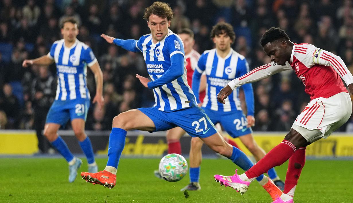 Tendangan keras Saka dari sisi kiri muka gawang Brighton gagal diantisipasi secara sempurna dan masuk melalui celang kolong kaki kiper Bart Verbruggen. (AP Photo/Alastair Grant)