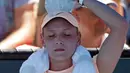 Petenis Kroasia Donna Vekic mendinginkan kepalanya dengan es saat istirahat selama bertanding melawan Nao Hibino dari Jepang dalam pertandingan putaran pertama Australia Terbuka 2018 di Melbourne, Australia, (16/1). (AP Photo / Ng Han Guan)