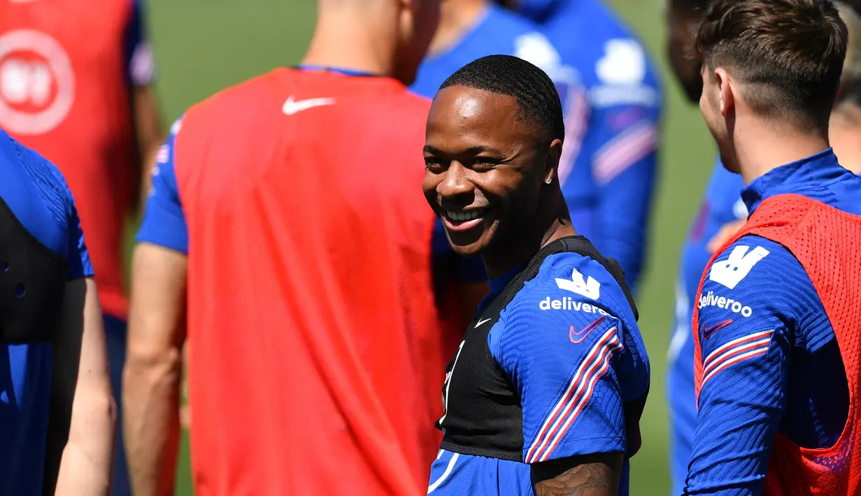 Penyerang Inggris, Raheem Sterling tersenyum saat mengikuti sesi latihan menjelang kompetisi Piala Eropa 2020 di stadion St. George's Park di Burton-upon-Trent  (9/6/2021). Inggris akan bertanding melawan Kroasia pada Grup D Piala Eropa 2020 di Stadion Wembley. (AFP/Justin Tallis)