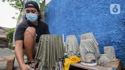 Seorang anak muda menyelesaikan pembuatan pot tanaman berbahan dasar kain bekas di  Cibodas, Kota Tangerang, Minggu (3/10/2021). Para pemuda ini memanfaatkan PPKM untuk membuat Pot tanaman daur ulang yang dipasarkan mulai harga Rp. 30 ribu hingga Rp. 80 ribu. (Liputan6.com/Angga Yuniar)
