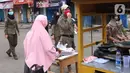 Petugas Satpol PP mengimbau warga untuk menggunakan masker dan menjaga jarak di Pasar Lama, Kota Tangerang, Banten, Sabtu (9/6/2020). Pemkot Tangerang melakukan penegasan pada PSBB tahap dua dengan menugaskan petugas di keramaian guna memutus rantai penyebaran COVID-19.  (Liputan6.com/Angga Yuniar)