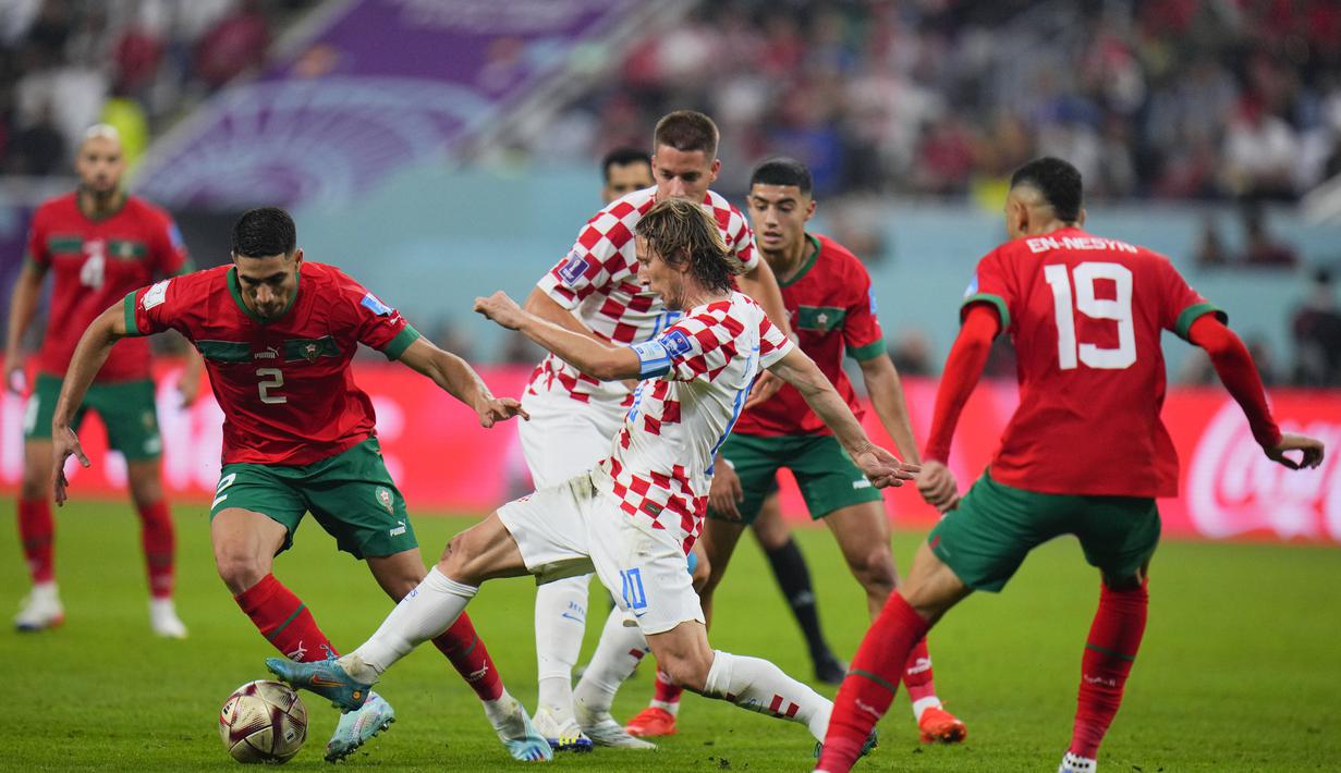 Bek Maroko, Achraf Hakimi berusaha melewati gelandang Kroasia, Luka Modric selama pertandingan playoff perebutan peringkat ketiga Piala Dunia 2022 di Khalifa International Stadium di Doha, Qatar, Sabtu (17/12/2022). Kroasia meraih juara ketiga Piala Dunia 2022 usai menang 2-1 atas Maroko. (AP Photo/Hassan Ammar)