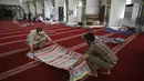 Pria Muslim yang mengenakan masker bersiap untuk duduk di Masjid Agung Faisal pada awal Itikaf, di sebuah masjid untuk pria selama bulan suci Ramadhan di Islamabad (3/5/2021). (AFP/Aamir Qureshi)