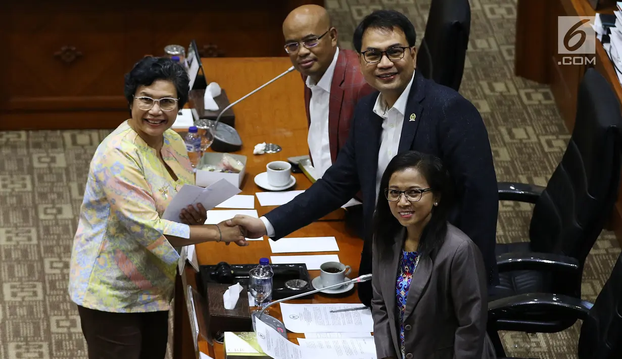 Calon Pimpinan KPK Lili Pintauli Siregar (kiri) berjabat tangan dengan Ketua Komisi III DPR Aziz Syamsuddin usai menerima amplop berisi tema makalah yang harus dibuat, saat uji kelayakan dan kepatutan capim KPK di Kompleks Parlemen, Senayan, Jakarta, Senin (9/9/2019). (Liputan6.com/Johan Tallo)