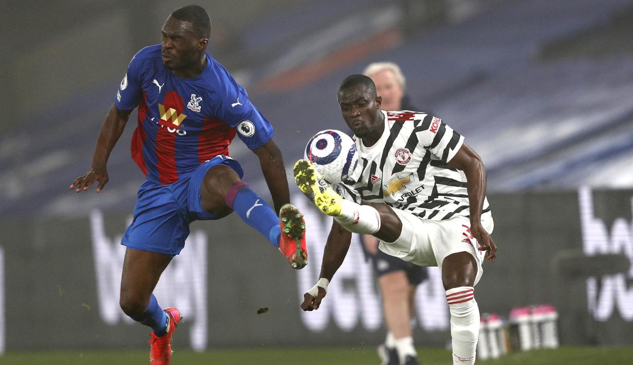 Striker Crystal Palace, Christian Benteke berebut bola dengan bek Manchester United, Eric Bailly pada pertandingan lanjutan Liga Inggris di stadion Selhurst Park di London, Kamis (4/3/2021). Dengan hasil ini, MU tetap berada di peringkat kedua klasemen dengan poin 51. (Adrian Dennis/Pool via AP)