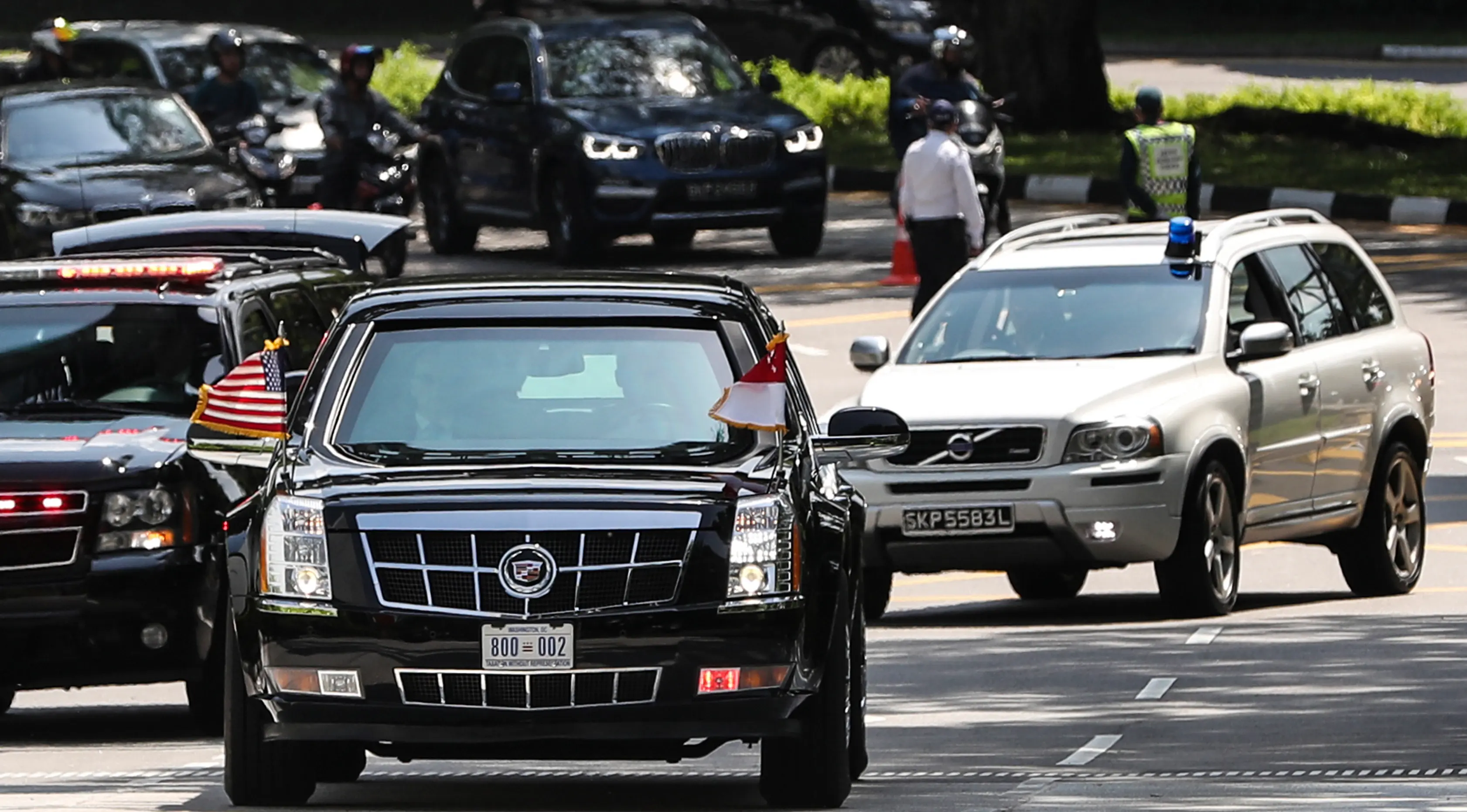 Iring-iringan mobil Presiden AS, Donald Trump memasuki kediaman resmi PM Lee Hsien Loong di Istana Singapura, Senin (11/6). Kedua tokoh tersebut akan membahas hubungan AS-Singapura yang disusul dengan makan siang bersama. (AP/Joseph Nair)
