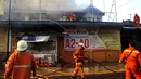 Petugas berupaya memadamkan api yang membakar sebuah percetakan dan pabrik roti di Jalan Cawang Baru, Kavling Otista, Jakarta, Selasa (19/9). Hingga berita dituliskan belum diketahui ada tidaknya korban jiwa dalam peristiwa ini (Liputan6.com/Angga Yuniar)