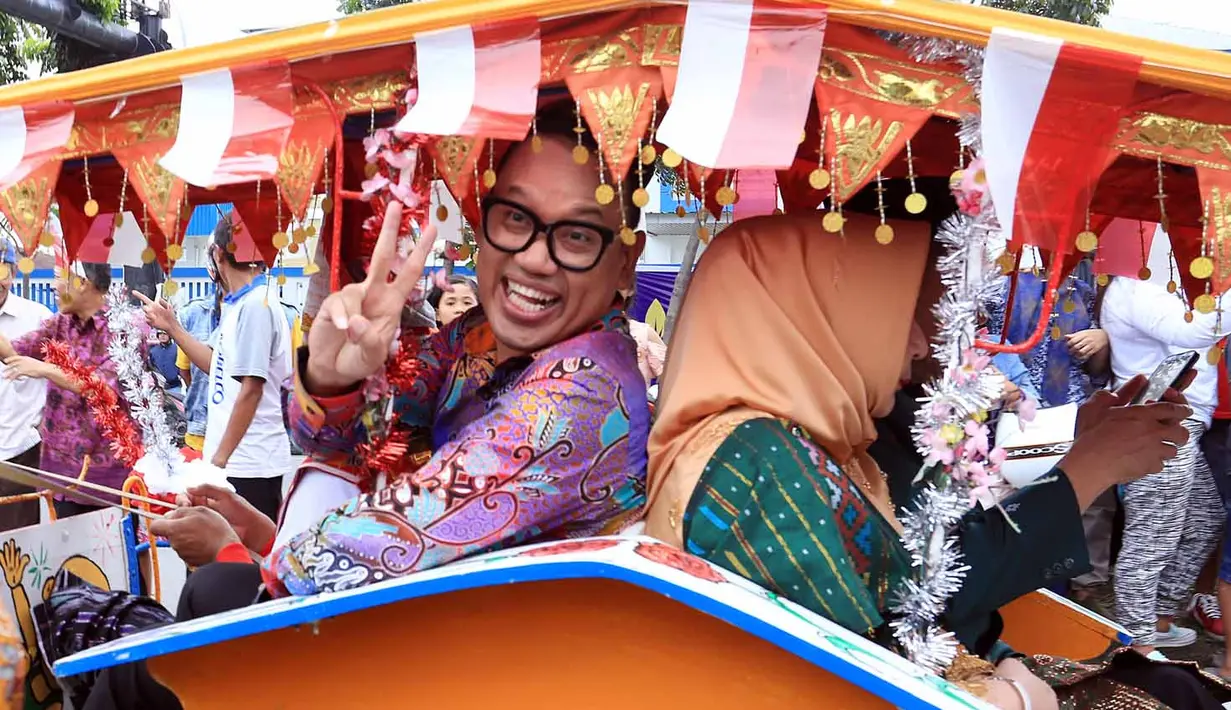 Dalam acara kirab budaya pada pernikahan Kahiyang Ayu dan Bobby Nasution, terlihat dalam rombongan kereta presenter Uya Kuya beserta keluarganya. "Halo kita lagi naik kuda nih, pakai andong," tulis istrinya Astrid. (Deki Prayoga/Bintang.com)
