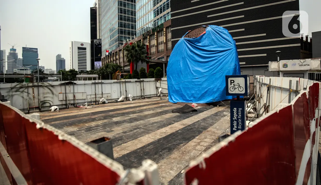 Suasana Proyek Pembangunan tugu sepeda di Jalan Jenderal Sudirman, Jakarta, Rabu (30/3/2022). Tugu yang dulu sempat boming dan digembar-gemborkan kini terlihat terhenti pengerjaannya dan hanya ditutup terpal. (Liputa6.com/Johan Tallo)