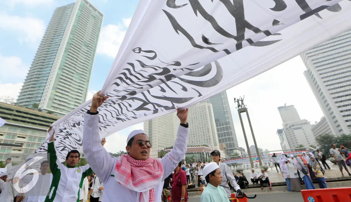 Massa yang dominan mengenakan warna putih melakukan aksi di Bundaran HI, Jakarta, Minggu (16/8/2015). Parade Tauhid yang diikuti berbagai organisasi massa Islam ini digelar dalam rangka mensyukuri kemerdekaan RI ke 70 tahun. (Liputan6.com/Faizal Fanani)