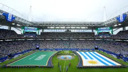 Para volunteer tetap mengangkat bendera tersebut selama seremoni tersebut berlangsung. Hal tersebut juga membuat bendera lawan, Uruguay juga sama perlakuannya untuk membuat visual yang seimbang. (AP Photo/Marta Lavandier)