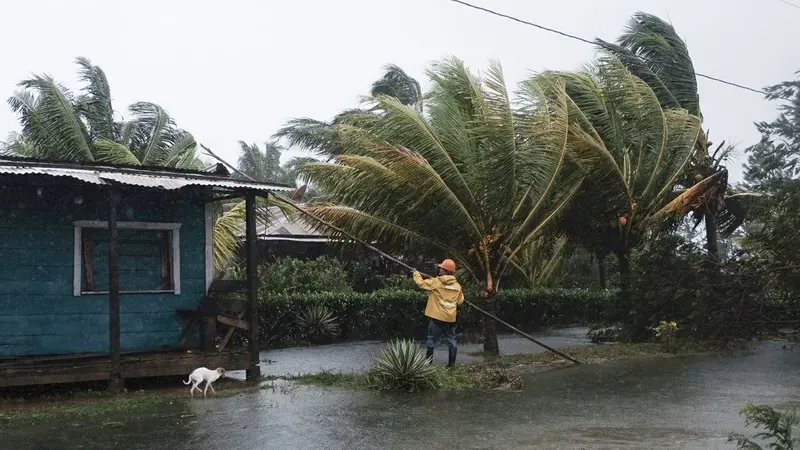 Seorang pria sedang memperbaiki atap rumah yang terkena air banjir akibat Badai Eta di Wawa, Nikaragua, pada Selasa (3/11/2020). (AP Photo/Carlos Herrera)