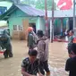 Babinsa Ternate Tanjung, Kodim 1309/Manado Sertu Sutimin bersama instansi terkait melakukan evakuasi warga yang terjebak banjir di Ternate Tanjung, Kecamatan Singkil, Kota Manado, Sulut, Minggu (21/1/2024).