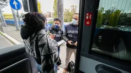 Polisi Carabinieri memeriksa kartu kesehatan Covid-19 penumpang bus pada hari pertama pemberlakuan ‘Super Green Pass’ di Roma, Senin (6/12/2021). Polisi Italia dapat memeriksa apakah pengunjung memiliki Green Pass yang menunjukkan bukti vaksinasi atau kesembuhan dari virus. (AP/Andrew Medichini)