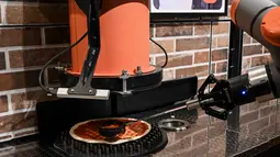 Foto yang diambil pada 1 Juli 2021 menunjukkan "Pazzi", robot pembuat pizza yang sedang bekerja di sebuah restoran di Paris. Pazzi adalah robot pertama yang menjalankan layanan restoran pizza tanpa bantuan pengawasan manusia. (BERTRAND GUAY/AFP)