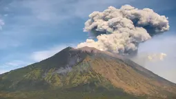 Gunung Agung mengeluarkan asap bercampur abu vulkanis terlihat dari desa Tulamben, Karangasem, Bali, Selasa (3/7). Walau terus mengalami letusan hampir sepekan terakhir, Gunung Agung masih berada pada status level III (siaga). (AFP/SONNY TUMBELAKA)