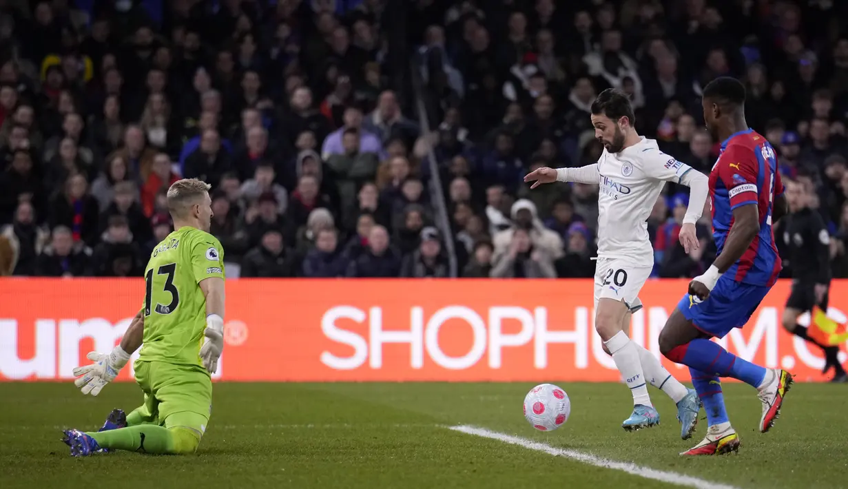 Kiper Crystal Palace, Vicente Guaita melakukan penyelamatan di depan pemain Manchester City Bernardo Silva selama pertandingan lanjutan Liga Inggris di Selhurst Park, London, Selasa (15/3/2022). Manchester City bermain imbang atas Crystal Palace 0-0. (AP Photo/Matt Dunham)