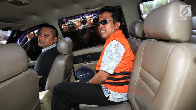 Ketua Umum PPP, Romahurmuziy dengan mengenakan rompi oranye memasuki mobil tahanan usai menjalani pemeriksaan di Gedung KPK, Jakarta, Sabtu (16/3). Romahurmuziy yang terjerat OTT di Surabaya pagi itu resmi menjadi tahanan KPK. (Liputan6.com/Faizal Fanani)