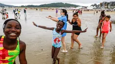Anak-anak menuju ke laut di pantai Cabourg, barat laut Prancis (18/8/2021). Acara ini sebagai bagian dari kampanye "Lupa Liburan" yang diselenggarakan oleh LSM Prancis Secours Populaire untuk anak-anak yang keluarganya tidak mampu pergi berlibur. (AFP/Sameer Al-Doumy)
