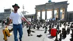 Seorang peternak sapi perah menyebarkan sepatu boots selama aksi protes di depan gerbang Brandenburg, Berlin, Jerman, Senin (30/5).  Mereka menuntut harga produk susu yang lebih adil bagi para peternak. (REUTERS/Fabrizio Bensch)
