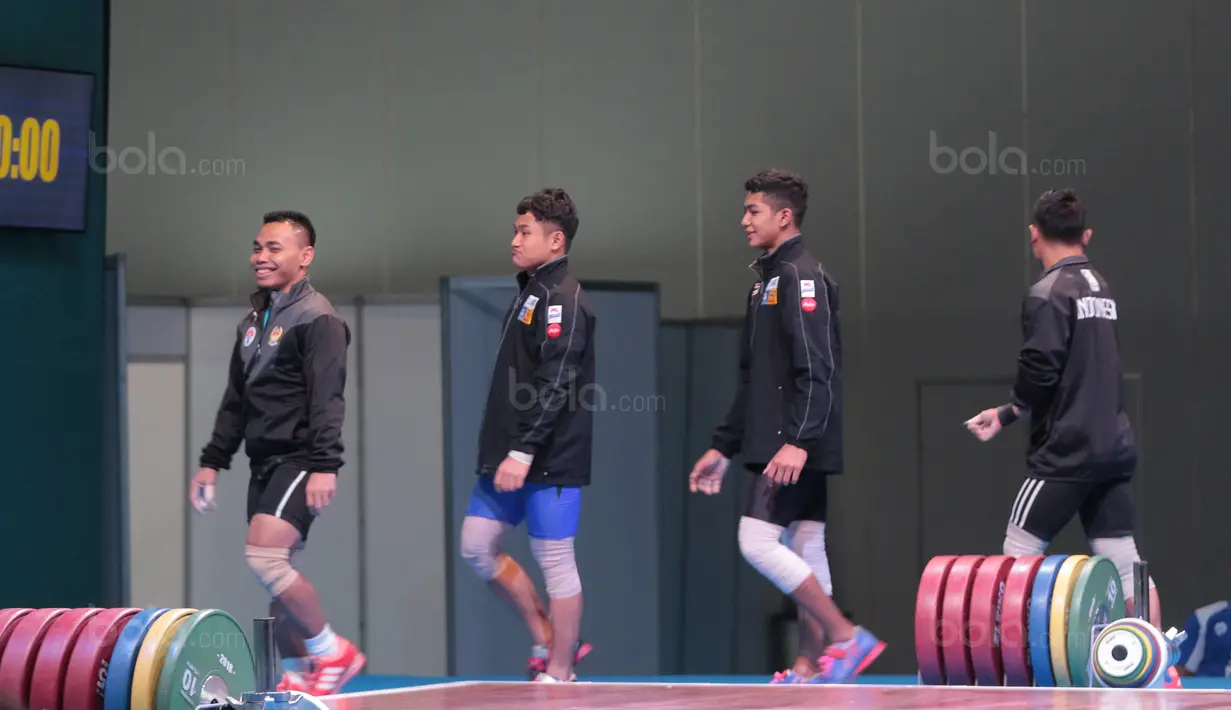Lifter Indonesia, Eko Yuli Irawan (kiri) saat perkenalan sebelum memulai pertandingan pada kelas 62 kg di Hall A Arena PRJ, Jakarta, Rabu (11/2/2018). Eko berhasil menyabet medali emas. (Bola.com/Nicklas Hanoatubun)