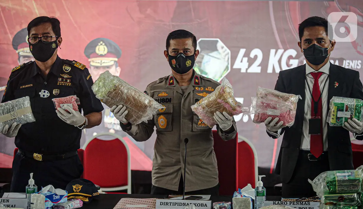 Karo Penmas Mabes Polri Brigjen Pol Rusdi Hartono (tengah) dan Dirtipid Narkoba Bareskrim Polri Brigjen Krisno Halomoan Siregar (kanan) menunjukkan barang bukti terkait penyelundupan narkoba jaringan Malaysia di Gedung Bareskrim Mabes Polri, Jakarta, Selasa (30/3/2021). (Liputan6.com/Faizal Fanani)