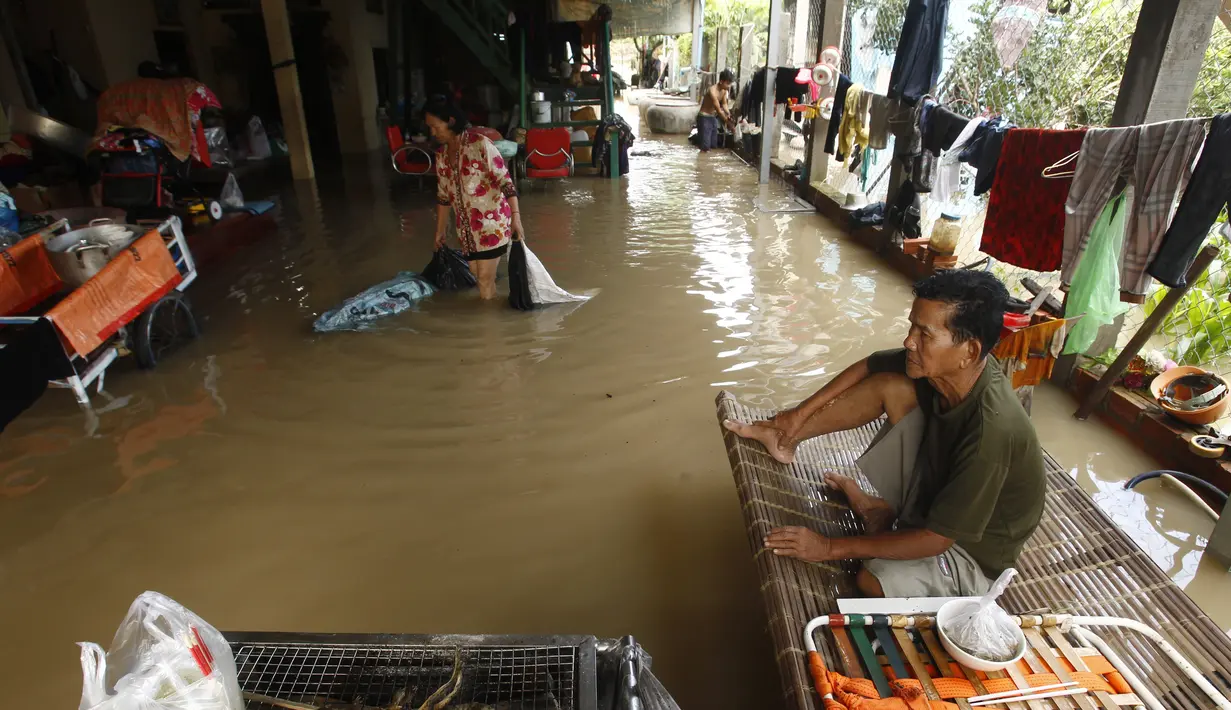 Seorang pria duduk di ranjang bambu saat banjir menyusul hujan di pinggiran Phnom Penh, Kamboja (14 /10/2020). Pejabat bencana Kamboja mengatakan Rabu bahwa lebih dari 10.000 orang telah dievakuasi ke tempat aman setelah badai tropis melanda yang menyebabkan banjir bandang.  (AP Photo/Heng Sinith)