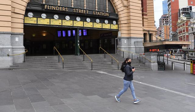 Warga berlari melewati Stasiun Flinder Street yang hampir sepi selama jam sibuk pagi hari ketika pemberlakukan lockdown di Melbourne, Jumat (28/5/2021). Melbourne kembali menerapkan lockdown untuk keempat kalinya setelah wabah COVID-19 menyebar cepat di wilayah tersebut. (William WEST/AFP)