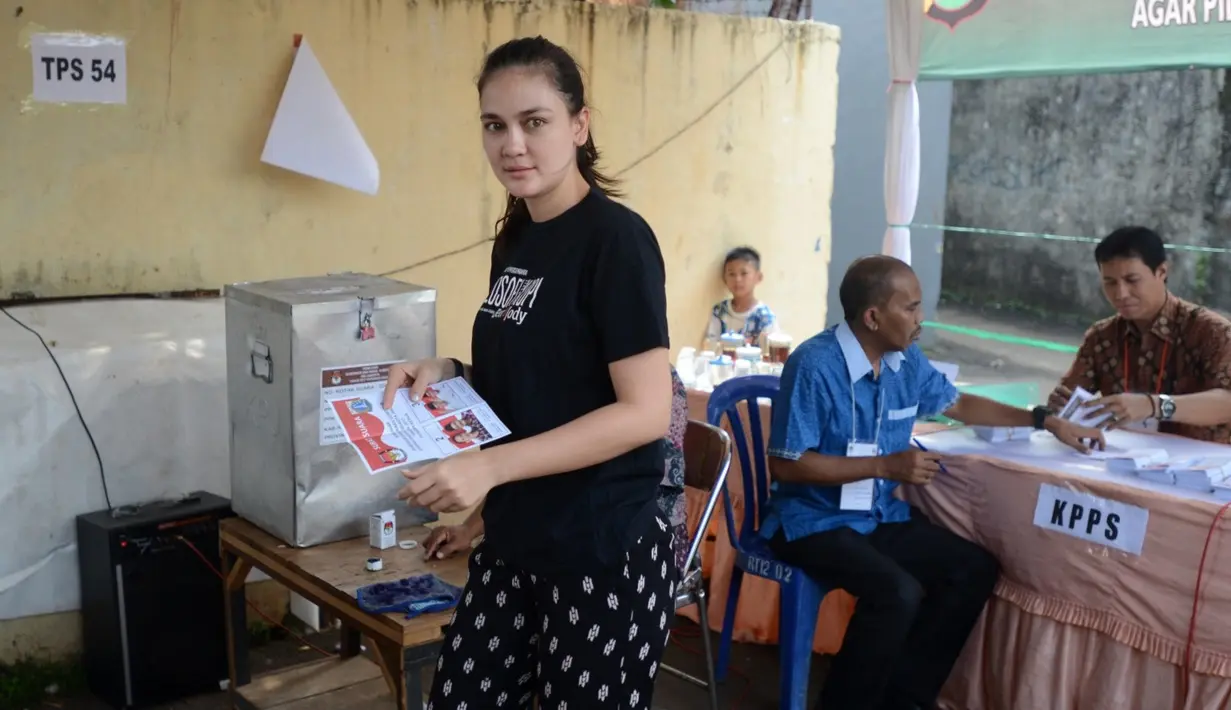 Saat datang ke TPS, Luna terlihat santai dengan mengenakan kaos hitam yang bertuliskan film yang belum lama ini ia terlibat, Filosofi Kopi. Dengan sendal jepit dan celana panjang hitam biasa dipakai tidur. (Adrian Putra/Bintang.com)