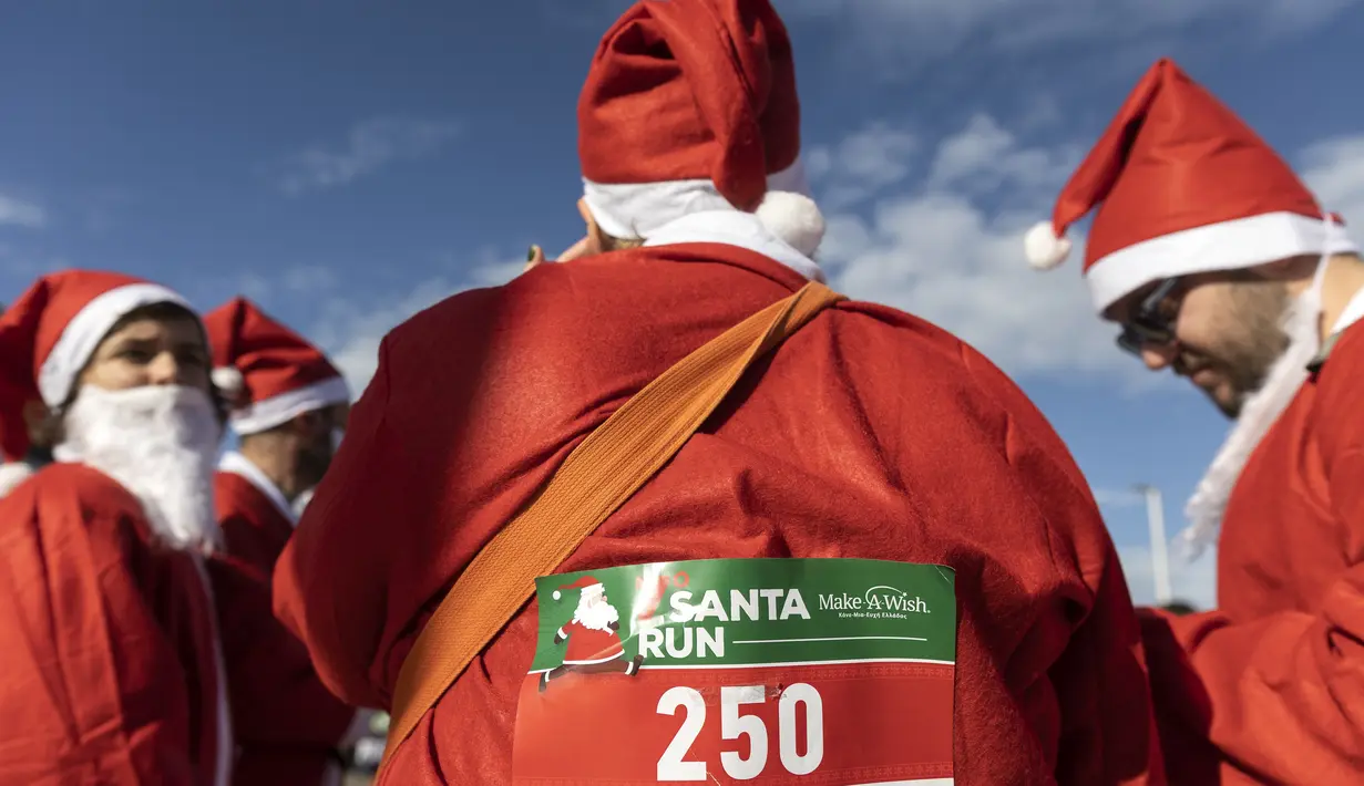 Orang-orang yang mengenakan kostum Sinterklas bersiap untuk ambil bagian dalam Athens Santa Run, di Athena, Yunani, Minggu (12/12/2021). Ratusan orang berpartisipasi mengikuti lomba lari untuk acara amal di area sekitar kompleks Stadion Olimpiade Athena. (AP Photo/Yorgos Karahalis)