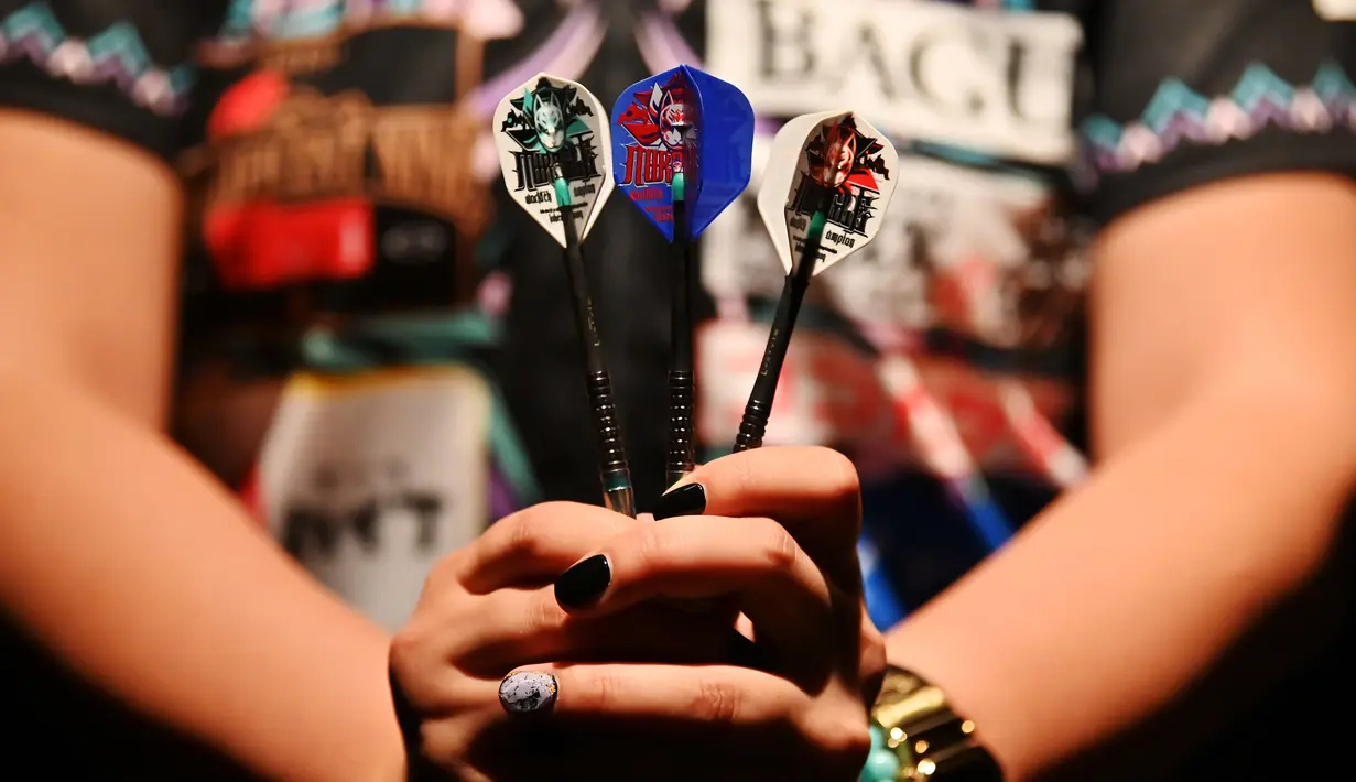 Mikuru Suzuki menunjukkan anak panah untuk bermain darts, Tokyo, Jepang, 8 April 2019. Suzuki berharap dapat menjadi semangat bagi pemain darts wanita untuk berprestasi. (CHARLY TRIBALLEAU/AFP)