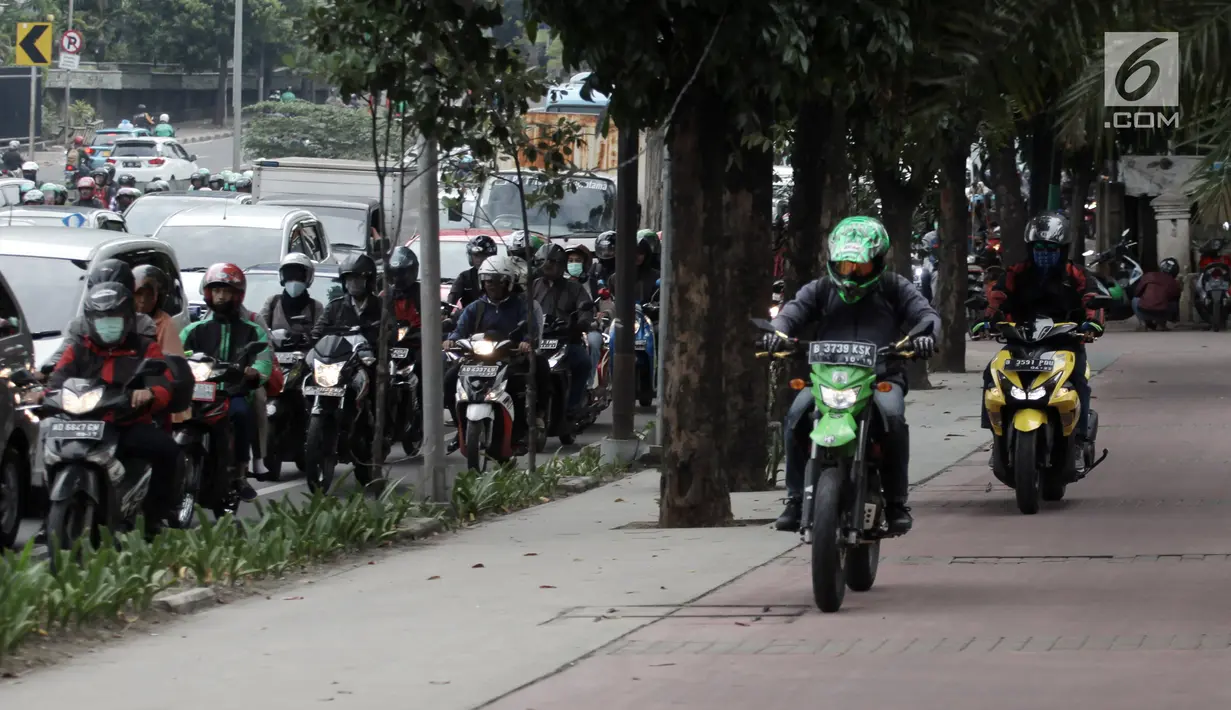 Pengendara yang tak sabar nekat menaiki jalur trotoar untuk menghindari kemacetan di Jalan Casablanca, Jakarta, Senin (8/1). Aksi pengendara sepeda motor tersebut membahayakan pajalan kaki yang melintas. (Liputan6.com/Arya Manggala Nuswantoro)