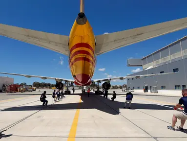 Anggota tim sekuat-tenaga untuk menarik pesawat DHL Boeing 757 sejauh 20 meter di Safi Aviation Park, Malta pada 1 Mei 2019. Kegiatan tarik pesawat tersebut merupakan rangkaian dalam rangka untuk penggalangan dana amal. (REUTERS/Darrin Zammit Lupi)