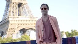 Aktor Hollywood Brad Pitt berpose saat sesi pemotretan untuk film 'Bullet Train' di Paris, Prancis, Sabtu (16/7/2022). Brad Pitt tampak keren dengan kacamata hitam berbingkai oranye dan aksesori kalung rantai emas. (AP Photo/Christophe Ena)