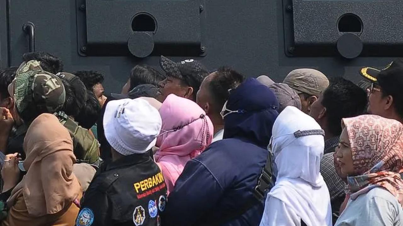 Tampak masyarakat yang antusias saat menyaksikan atraksi terjun payung pada peringatan HUT ke-78 TNI di Lapangan Silang Monumen Nasional (Monas).