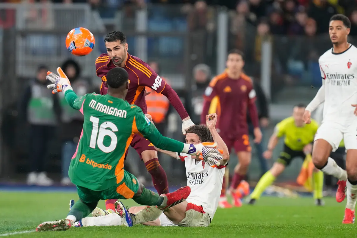 Mike Maignan berusaha menghalau usaha Zeki Celik mengancam gawangnya di laga AS Roma vs AC Milan di pekan ke-22 Liga Italia 2025/2026 di Olimpico, Senin (26/01/2026) dini hari WIB.