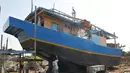 Pekerja mengecat badan kapal saat proses pembuatan di Karangsong, Indramayu, Jabar, Rabu (17/6). Pembuatan kapal berkapasitas sekitar 30 grosstone tersebut dapat memakan waktu 3-6 bulan. (Liputan6.com/Herman Zakharia)