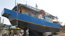 Pekerja mengecat badan kapal saat proses pembuatan di Karangsong, Indramayu, Jabar, Rabu (17/6). Pembuatan kapal berkapasitas sekitar 30 grosstone tersebut dapat memakan waktu 3-6 bulan. (Liputan6.com/Herman Zakharia)