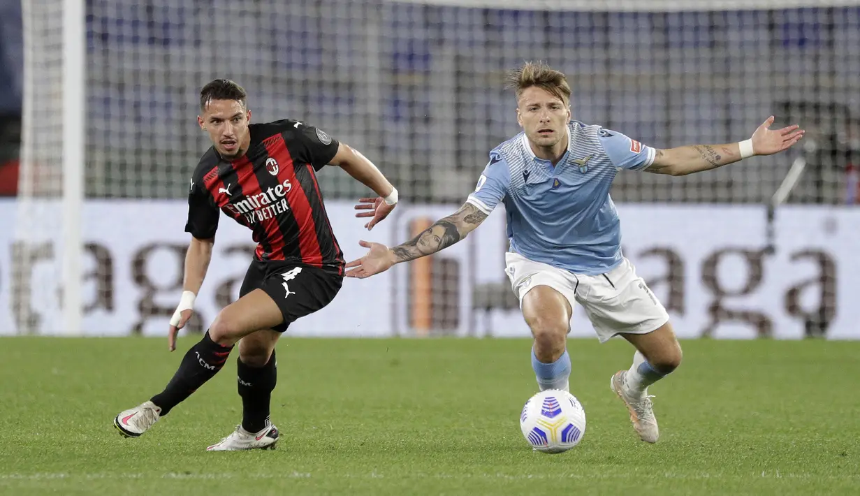 Penyerang Lazio, Ciro Immobile (kanan) dan gelandang AC Milan, Ismael Bennacer mengamati bola dalam laga pekan ke-33 Liga Italia 2020-2021 di Stadio Olimpico, Selasa dinihari WIB (27/4/2021). AC Milan kalah telak 3-0 saat menyambangi kandang Lazio. (AP Photo/Gregorio Borgia)