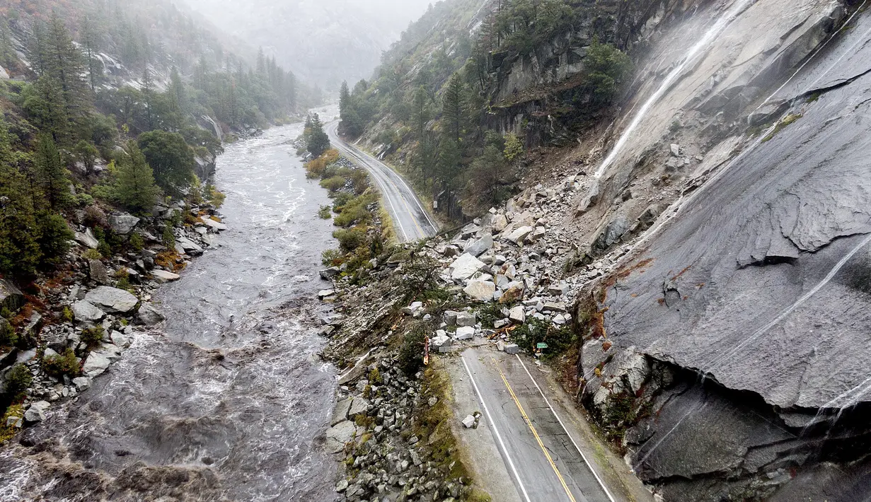 Batuan dan vegetasi menutupi Highway 70 menyusul tanah longsor di zona Dixie Fire di Plumas County, California, Minggu (24/10/2021). Badai kuat menerjang California Utara yang sempat mengalami kebakaran hutan, memicu tanah longsor dan banjir, juga membawa angin kencang. (AP Photo/Noah Berger)