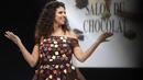 Pembawa acara TV Prancis Yasmine Oughlis membawakan kreasi pembuat cokelat Florent Thevenon dan desainer Ludivine Guillot yang dibuat dengan cokelat selama Chocolate Fair (Salon du Chocolat) di Paris pada Rabu (27/10/2021). (GEOFFROY VAN DER HASSELT / AFP)
