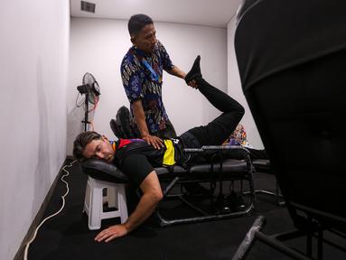 Seorang kru TV sedang menikmati fasilitas pijat selama Piala Dunia FIBA 2023 di Indonesia Arena, Senayan, Jakarta, Jumat (01/09/2023). (Bola.com/Bagaskara Lazuardi)